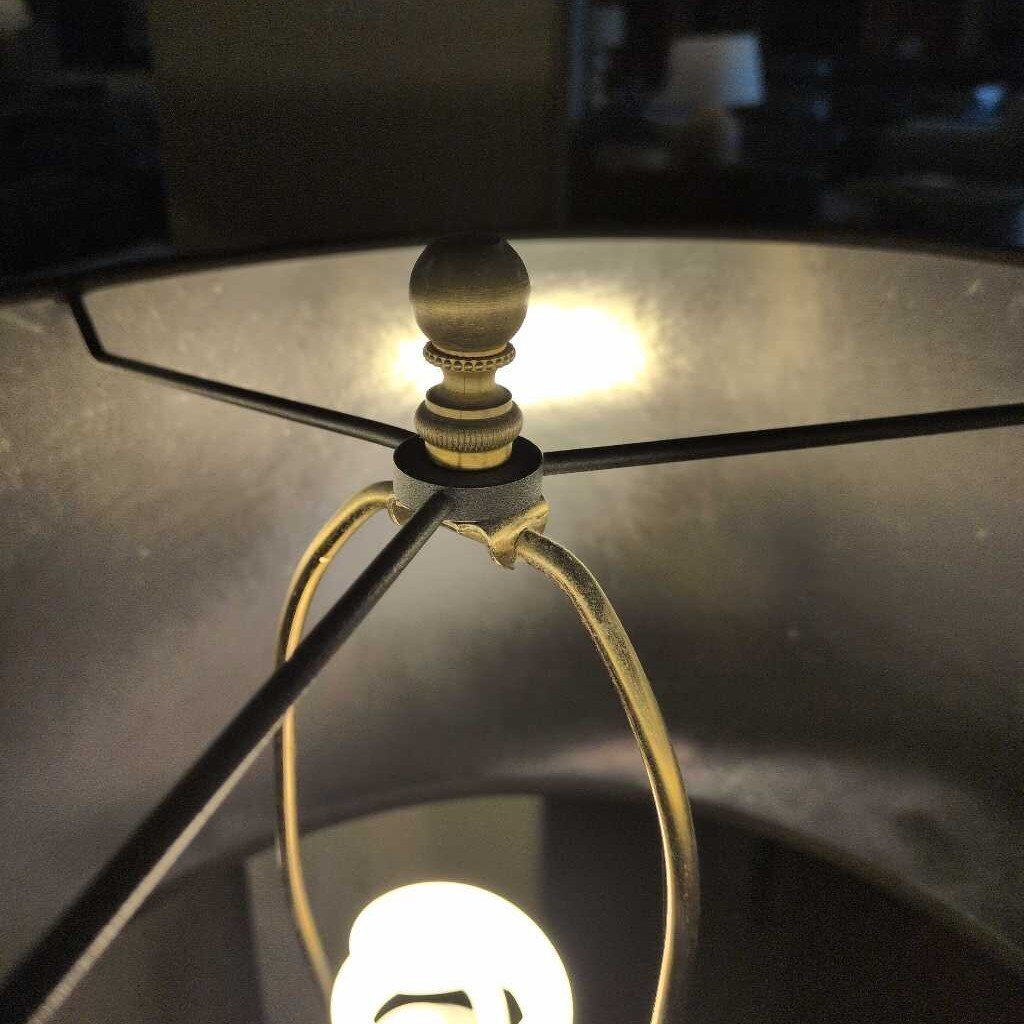 Close-up of a lamp with a metallic shade and bulb inside, blurred background