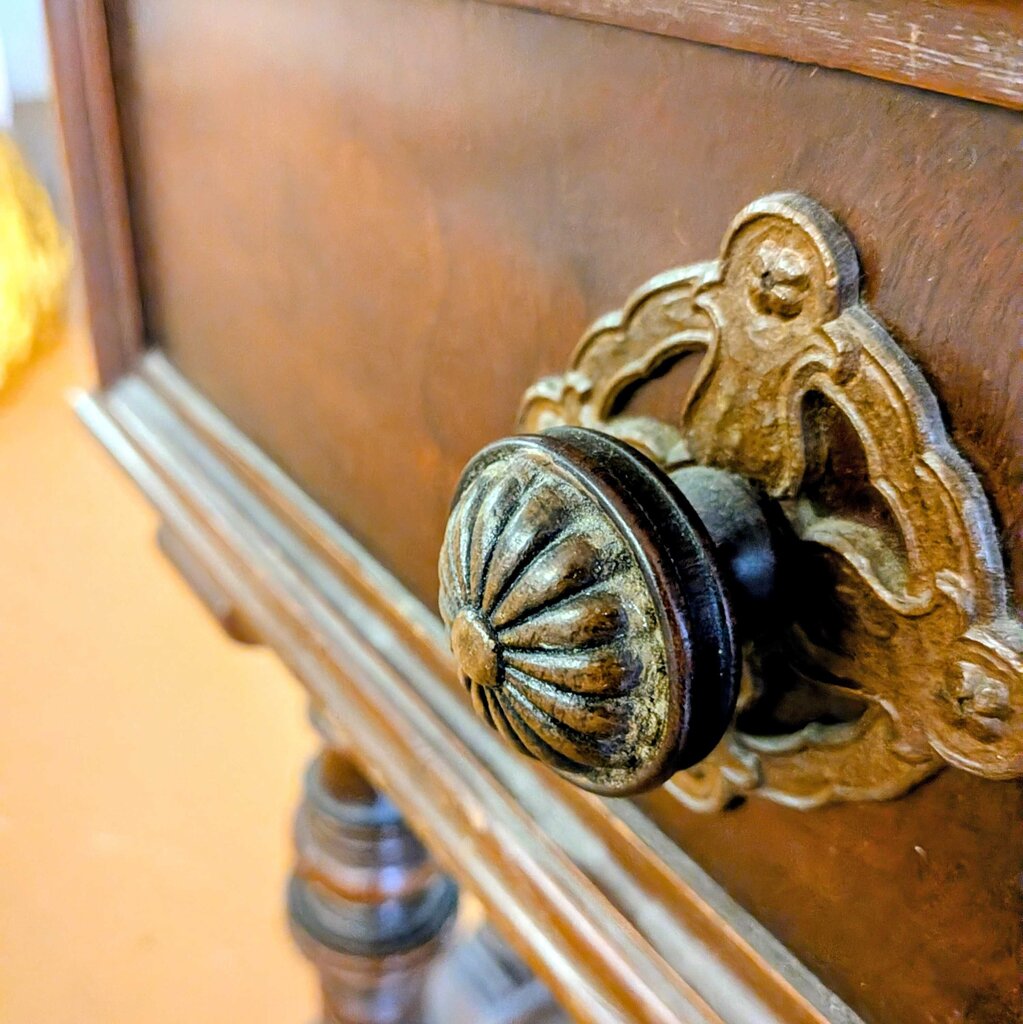 Close-up of a wooden door with an ornate brass doorknob