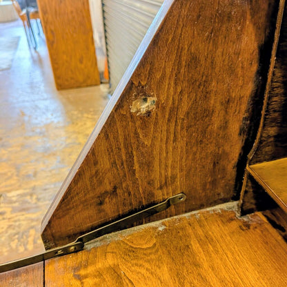 Close-up of a wooden surface with a metal handle and visible wear.