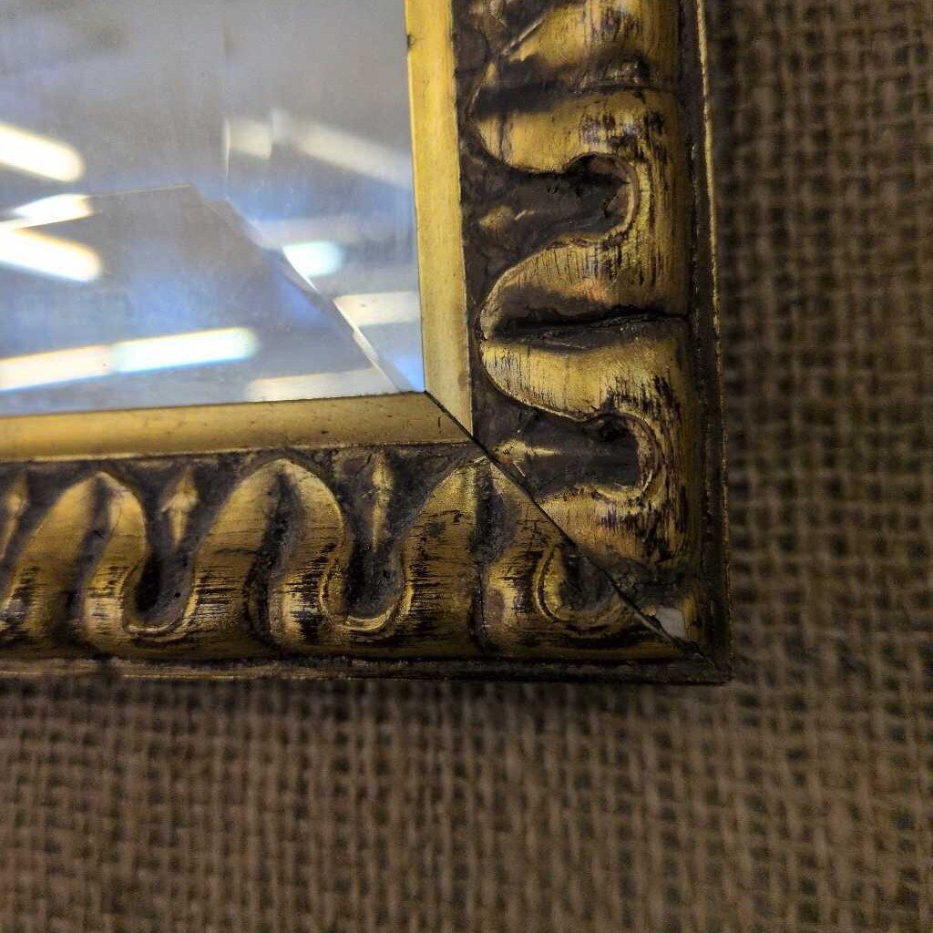 Close-up of a decorative wooden frame corner on a textured surface