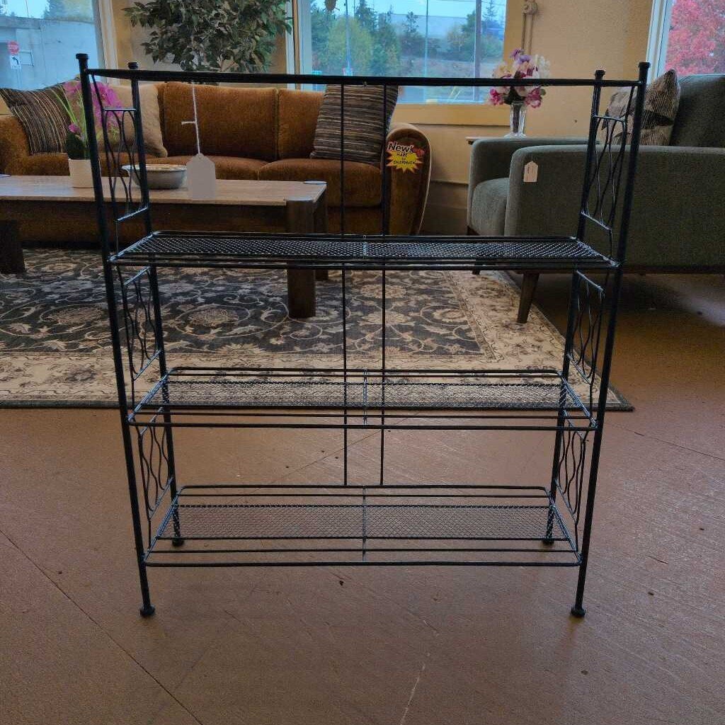 Black metal shelf in a living room setting with furniture and decor.