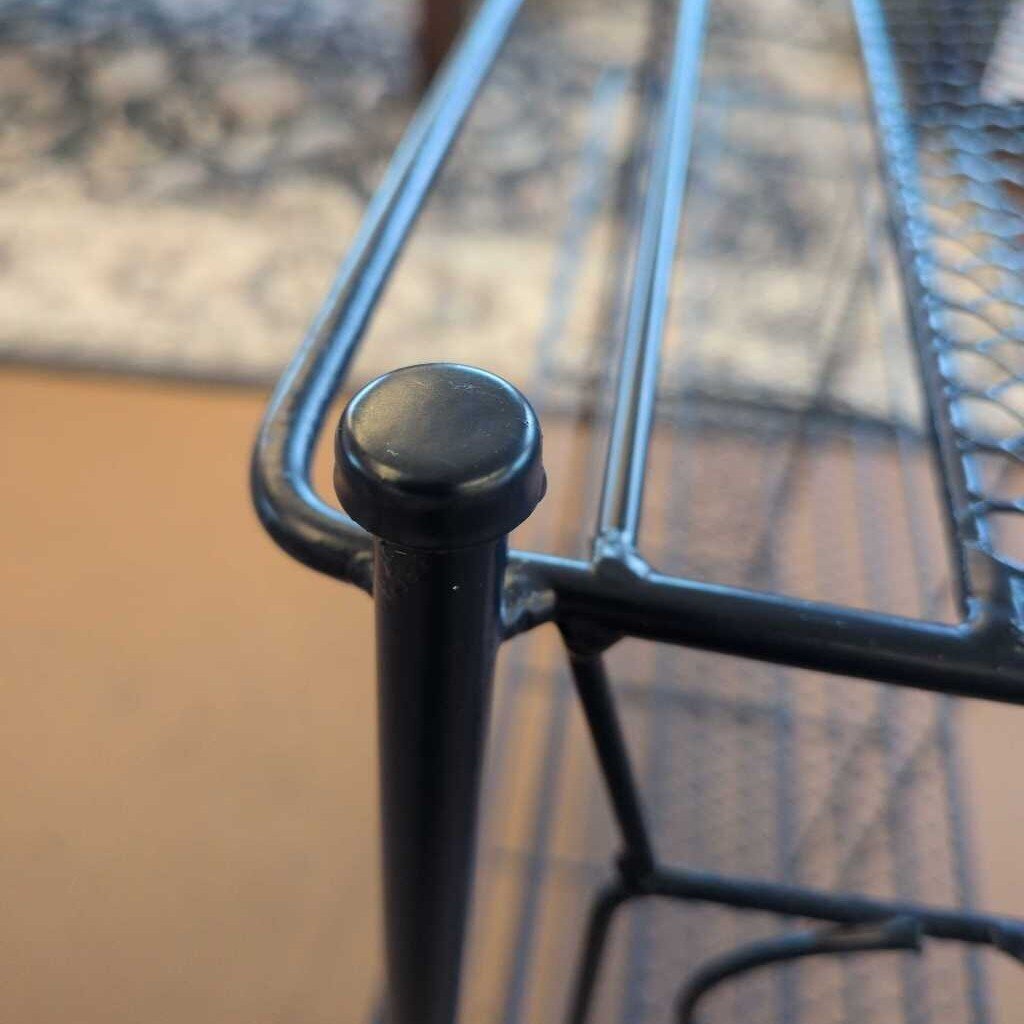 Close-up of a black metal chair leg with a blurred background