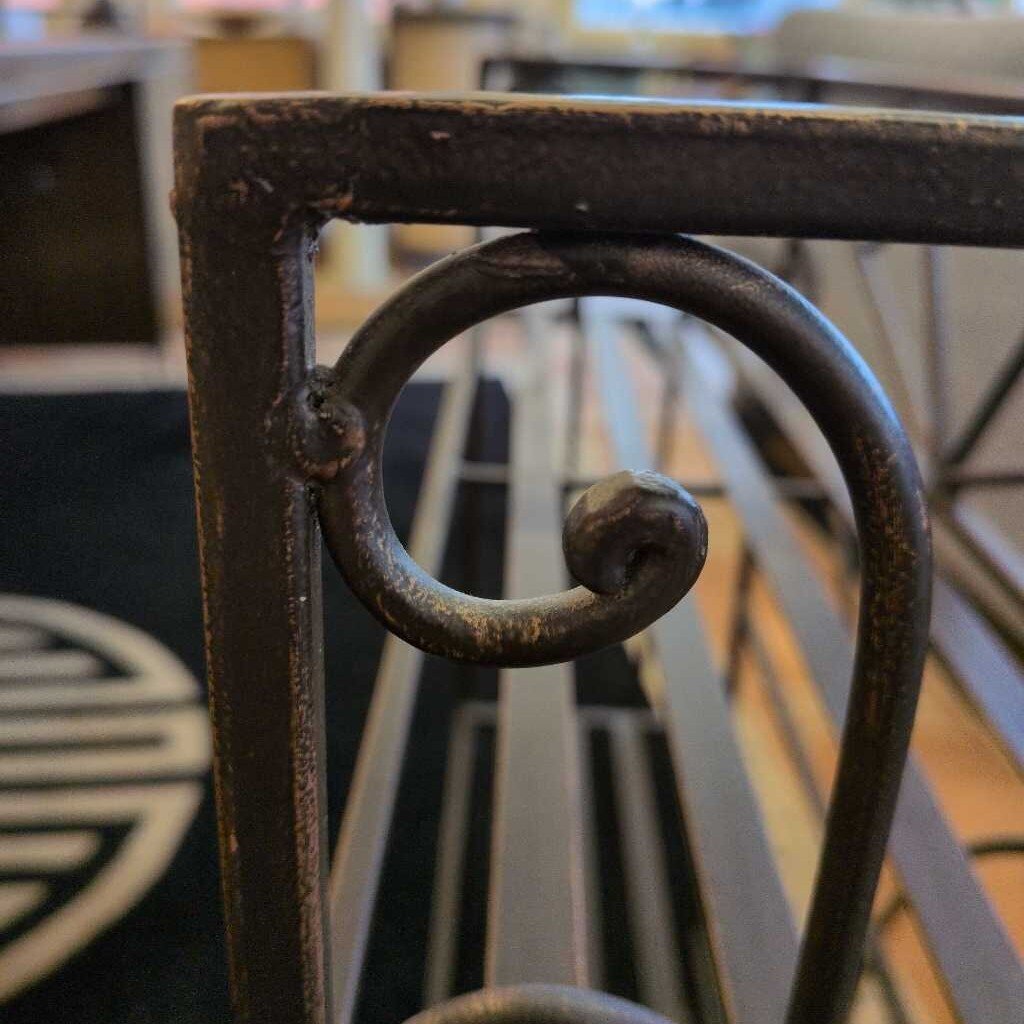 Close-up of a metal chair leg with decorative ring detail, blurred background