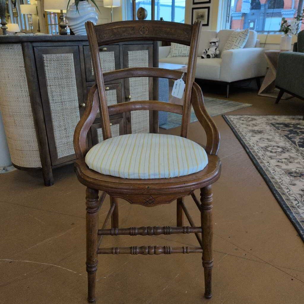Wooden chair with a striped cushion in a furniture store setting