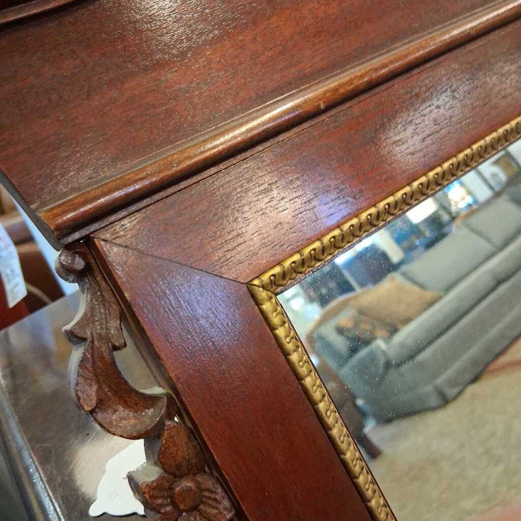 Close-up of a wooden mirror frame with intricate carvings