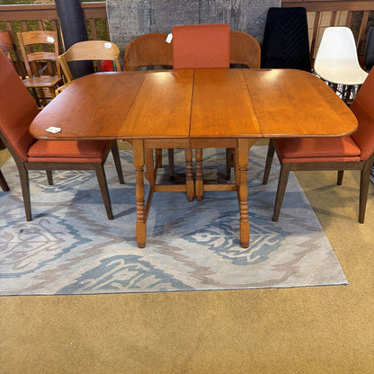 Wooden dining table with four chairs on a patterned rug