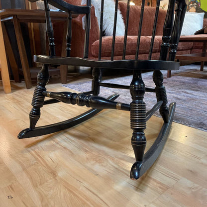 Wooden rocking chair on a wooden floor with a blurred background