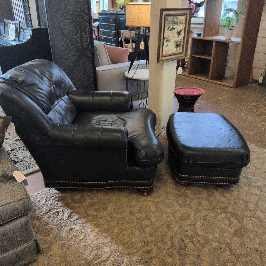 Black leather armchair and ottoman on a patterned carpet