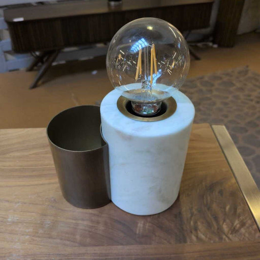 Light bulb in a cylindrical container on a wooden surface