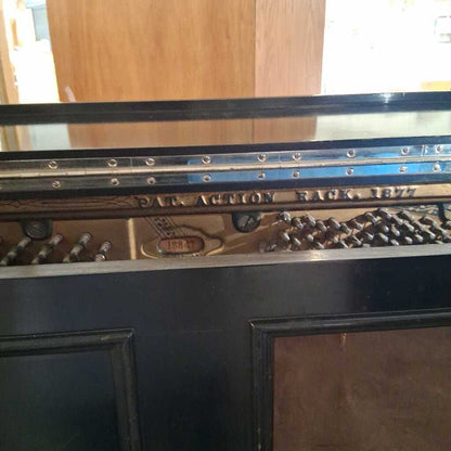 Close-up of a piano with visible brand name and serial number.