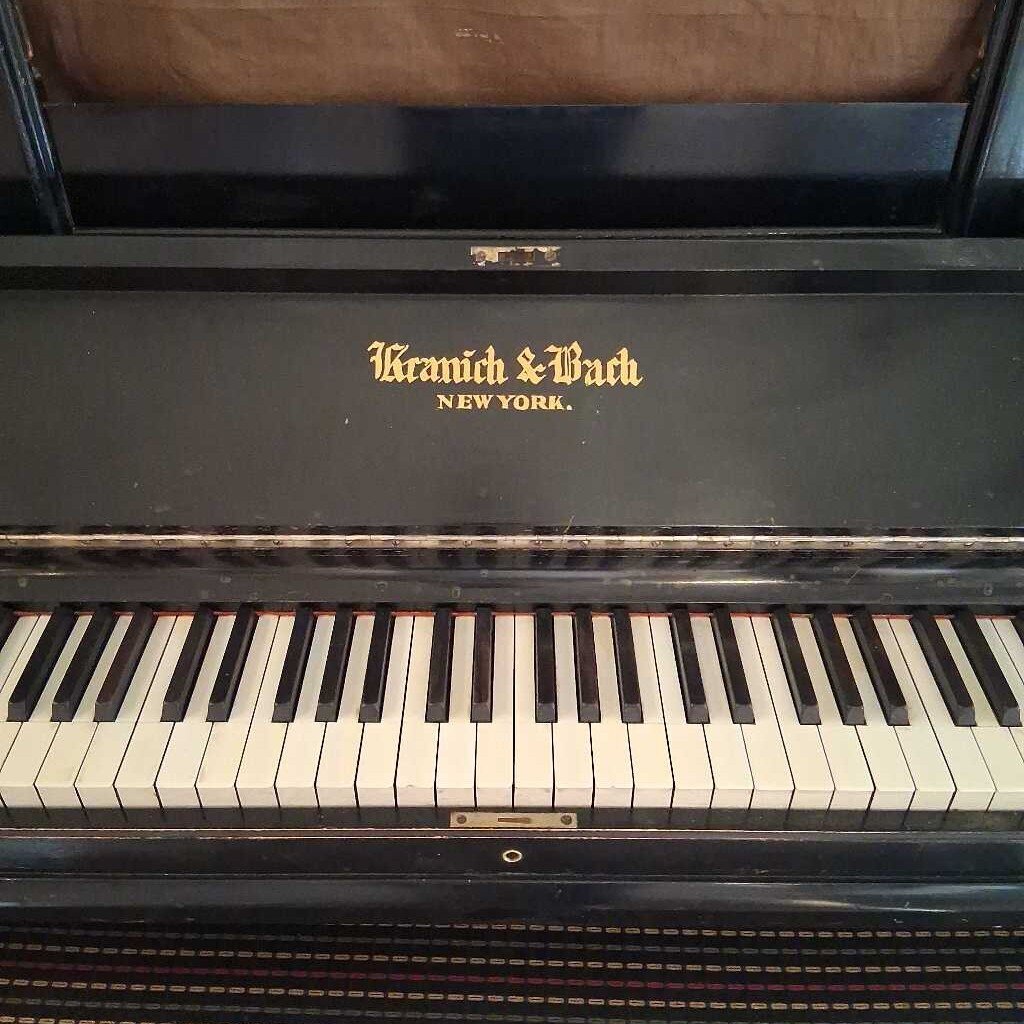 Vintage piano with 'Kranich & Bach New York' branding on the lid.