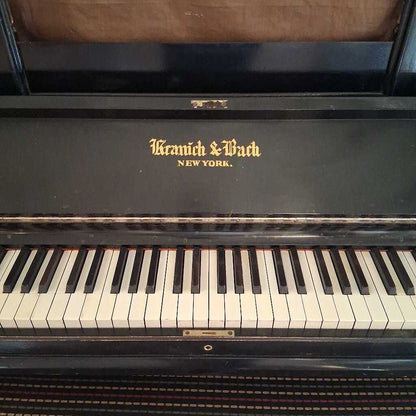 Vintage piano with 'Kranich & Bach New York' branding on the lid.