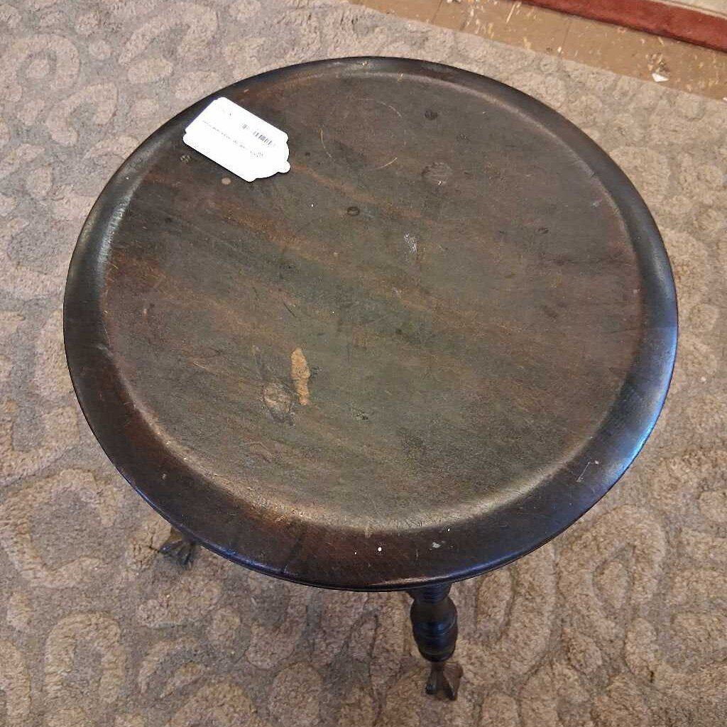 Round wooden table with a dark finish on a patterned carpet