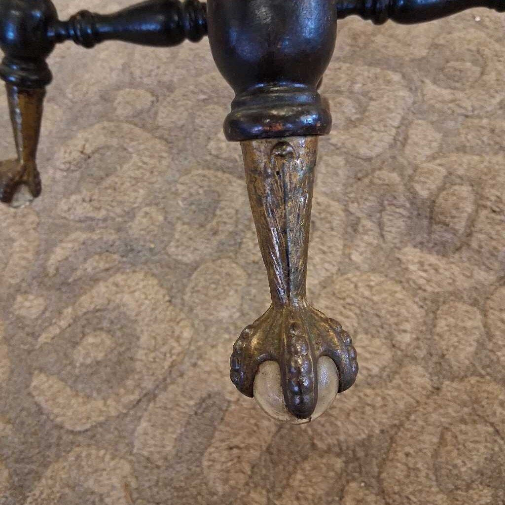 Close-up of a decorative metal foot on a textured surface