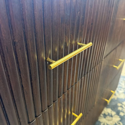 Wooden cabinet with gold handles on a patterned carpet