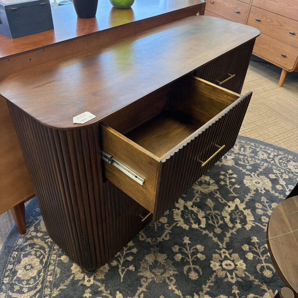 Wooden dresser with open drawer on a patterned rug