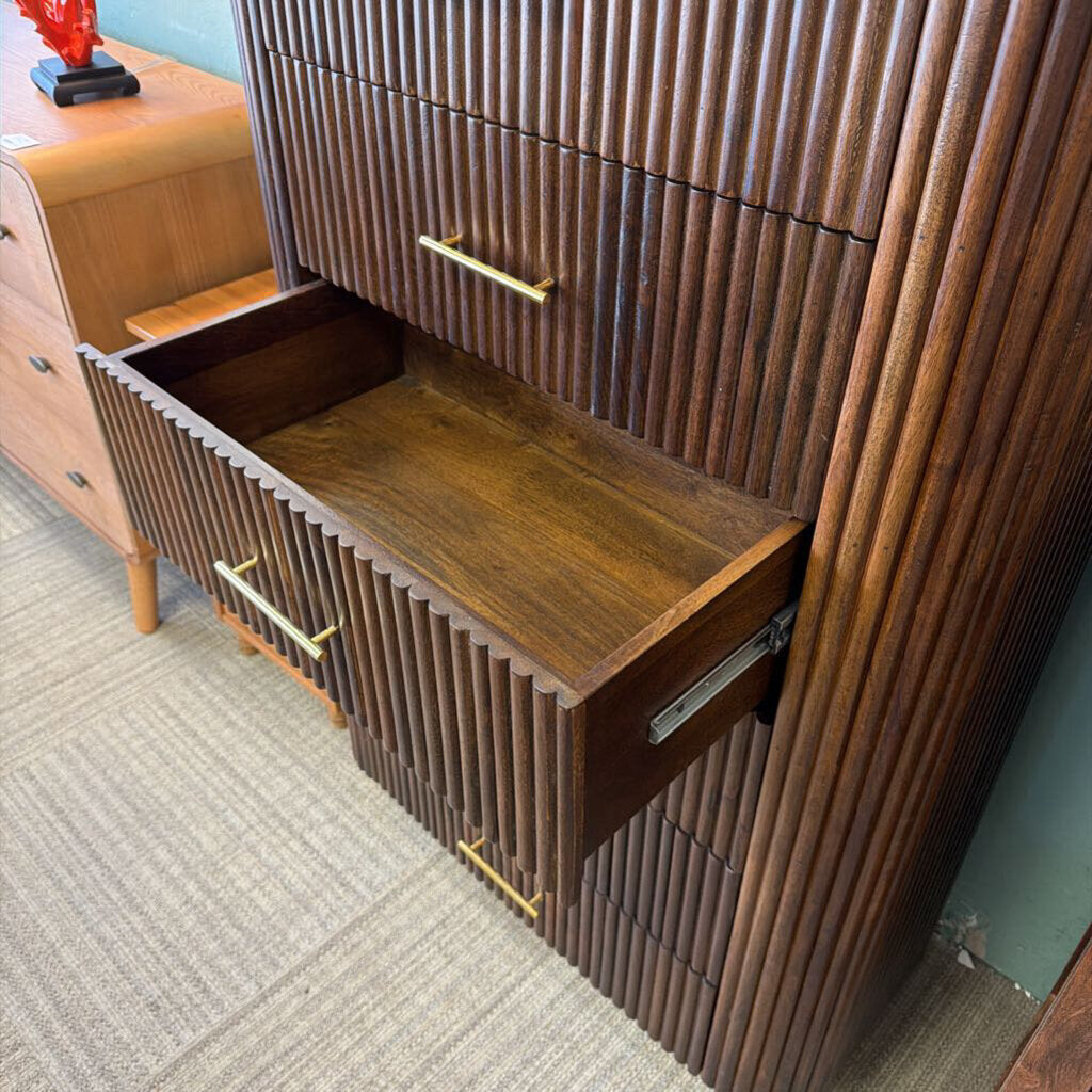 Wooden dresser with open drawer on a carpeted floor