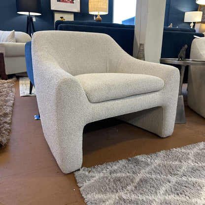 Gray armchair in a room with other furniture and decor
