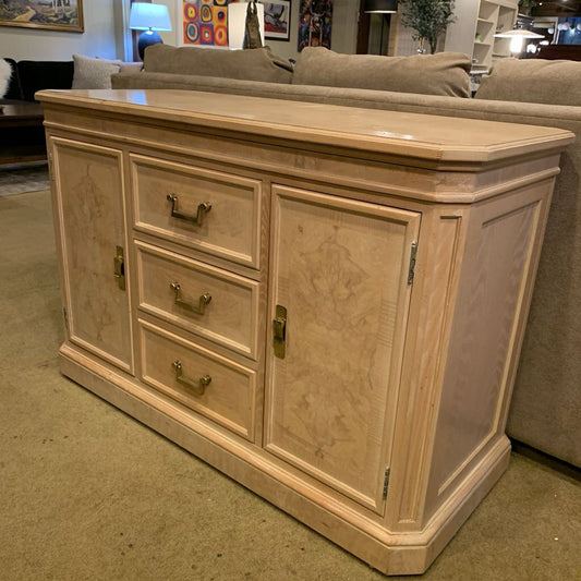 Light wood sideboard with drawers and doors in a room setting