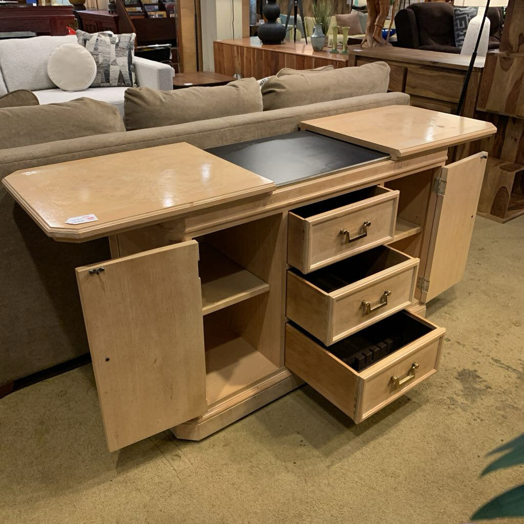 Wooden sideboard with open doors and drawers in a furniture store setting