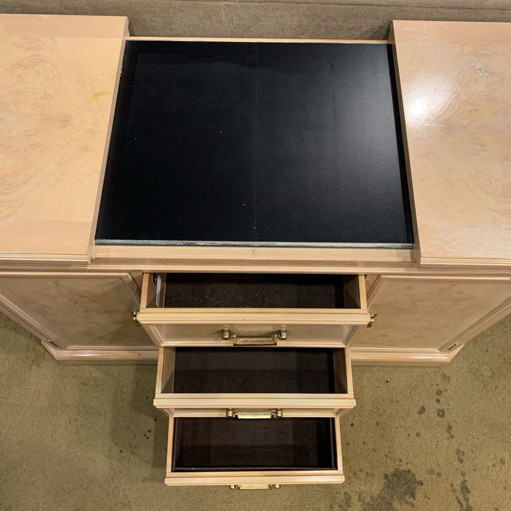 Wooden desk with open drawers and a black top.