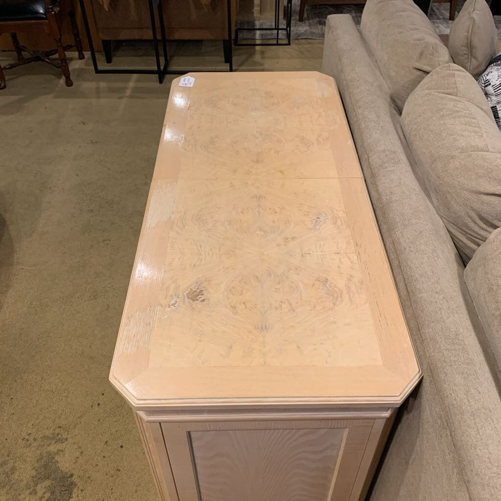 Beige marble coffee table next to a beige sofa in an indoor setting