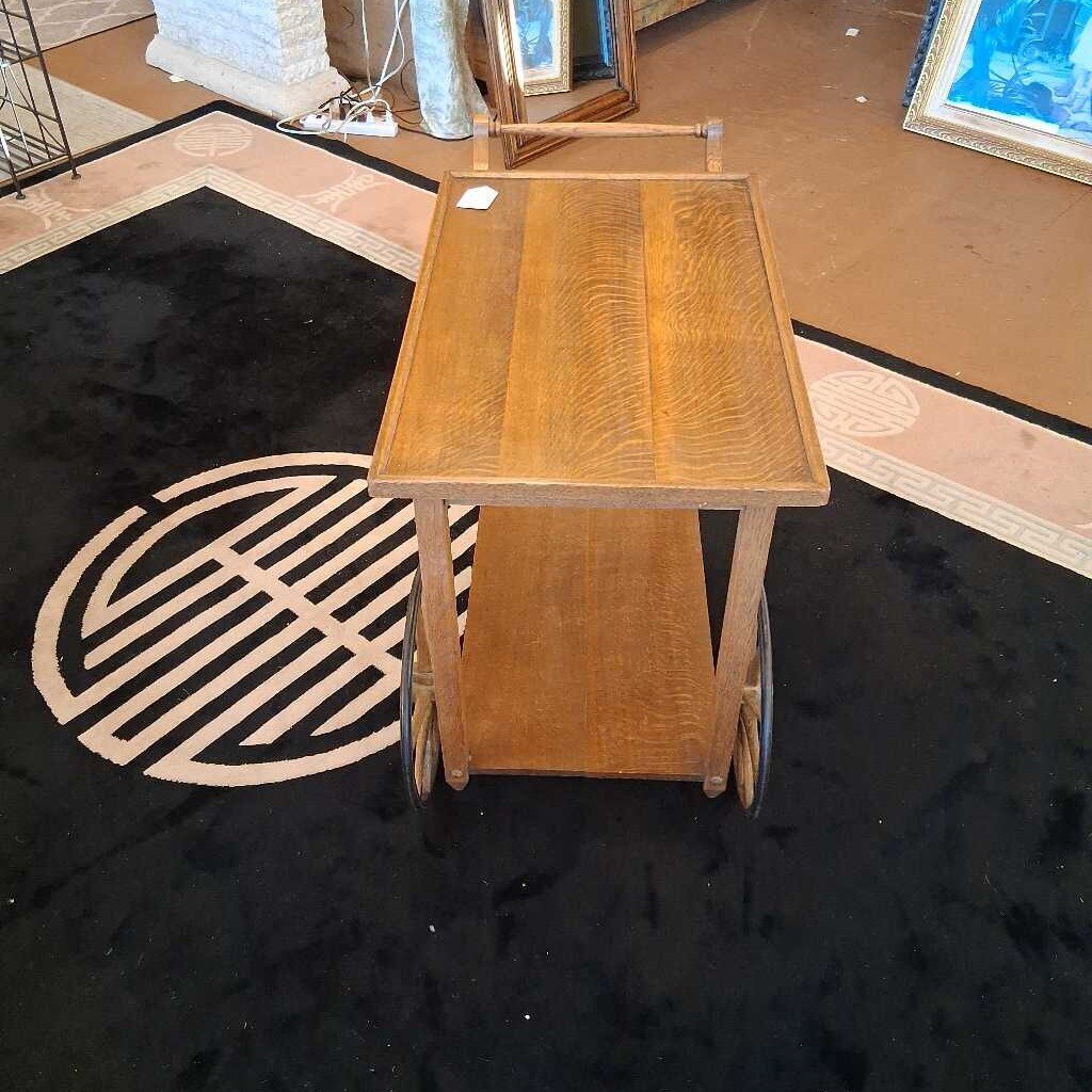 Wooden cart with wheels on a black floor