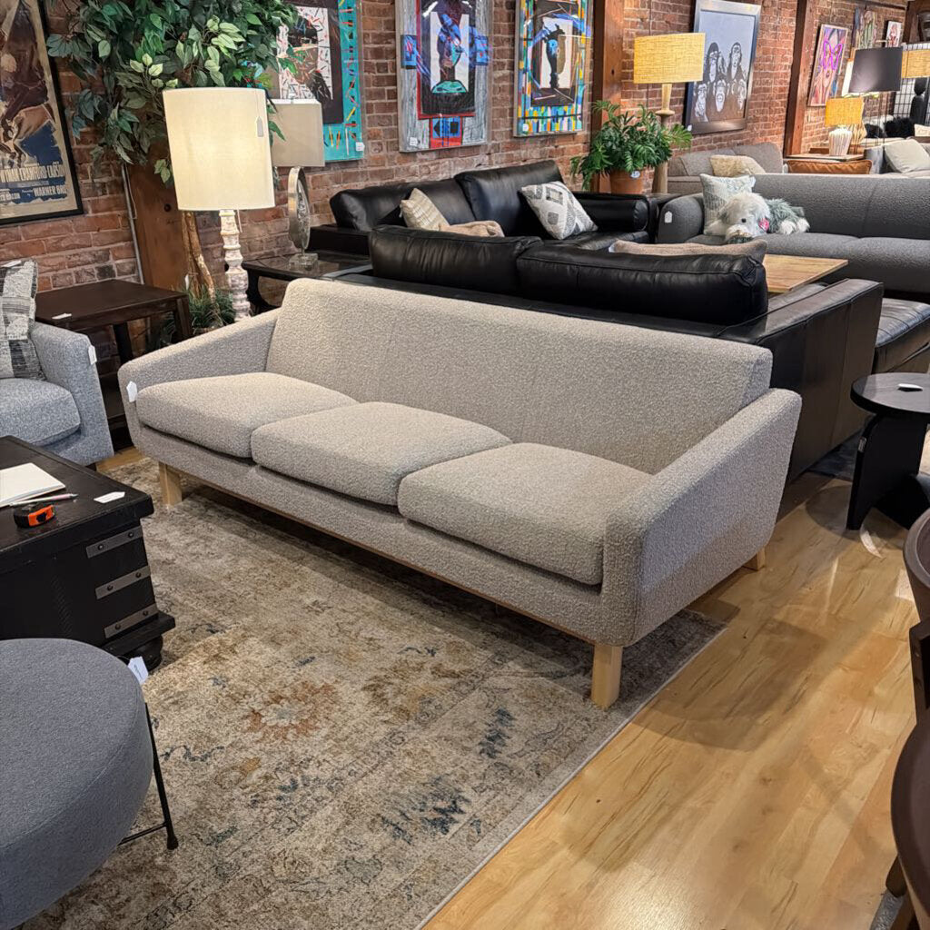 Living room with gray sofa, black leather couch, and decorative elements.