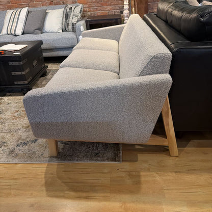 Gray sofa with wooden legs in a living room setting