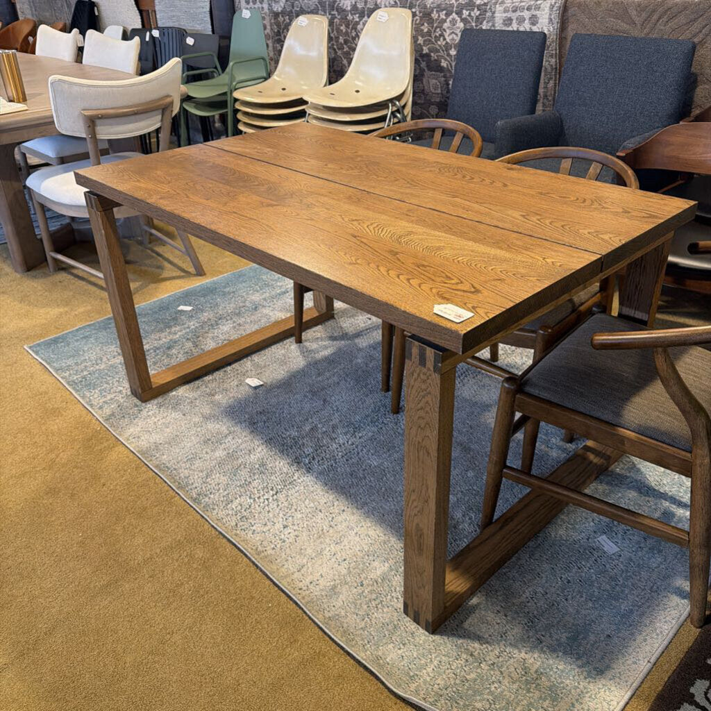 Wooden dining table with chairs in a showroom setting