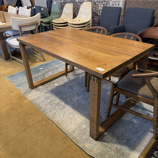 Wooden dining table with chairs in a showroom setting