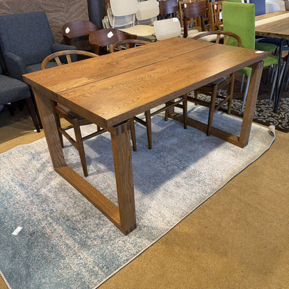 Wooden dining table with chairs in a showroom setting