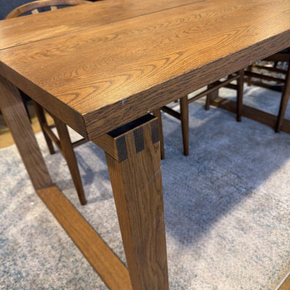 Wooden dining table with chairs on a carpeted floor