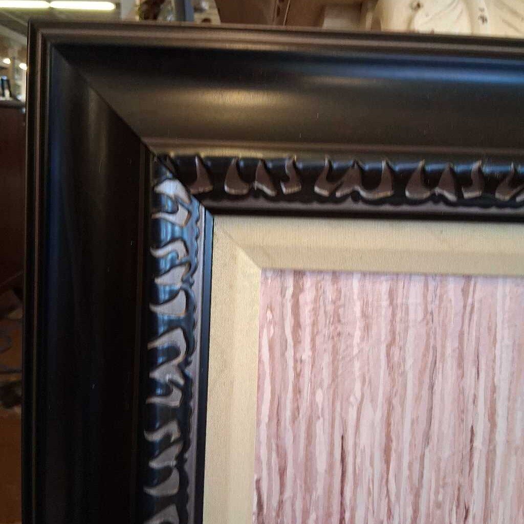 Close-up of a dark wooden picture frame with decorative molding.