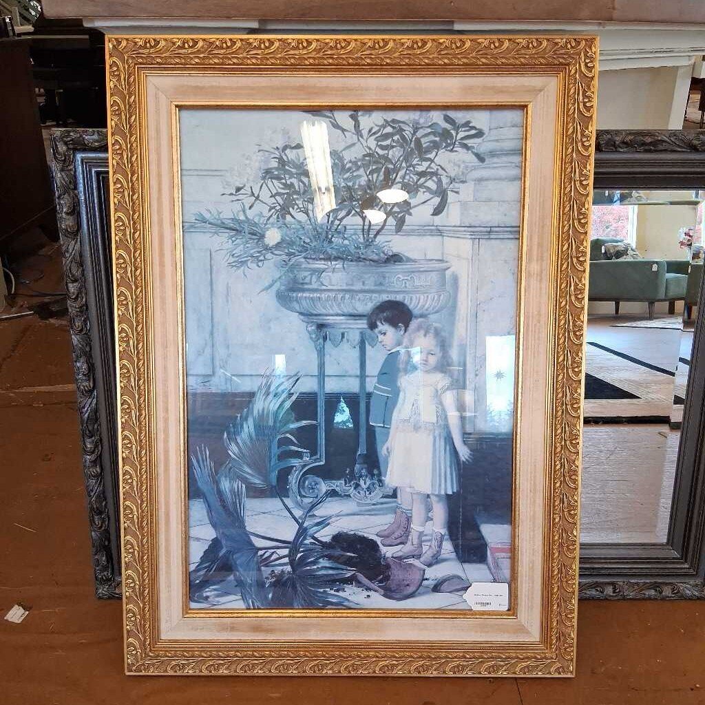 Framed artwork of two children by a fireplace with decorative elements.