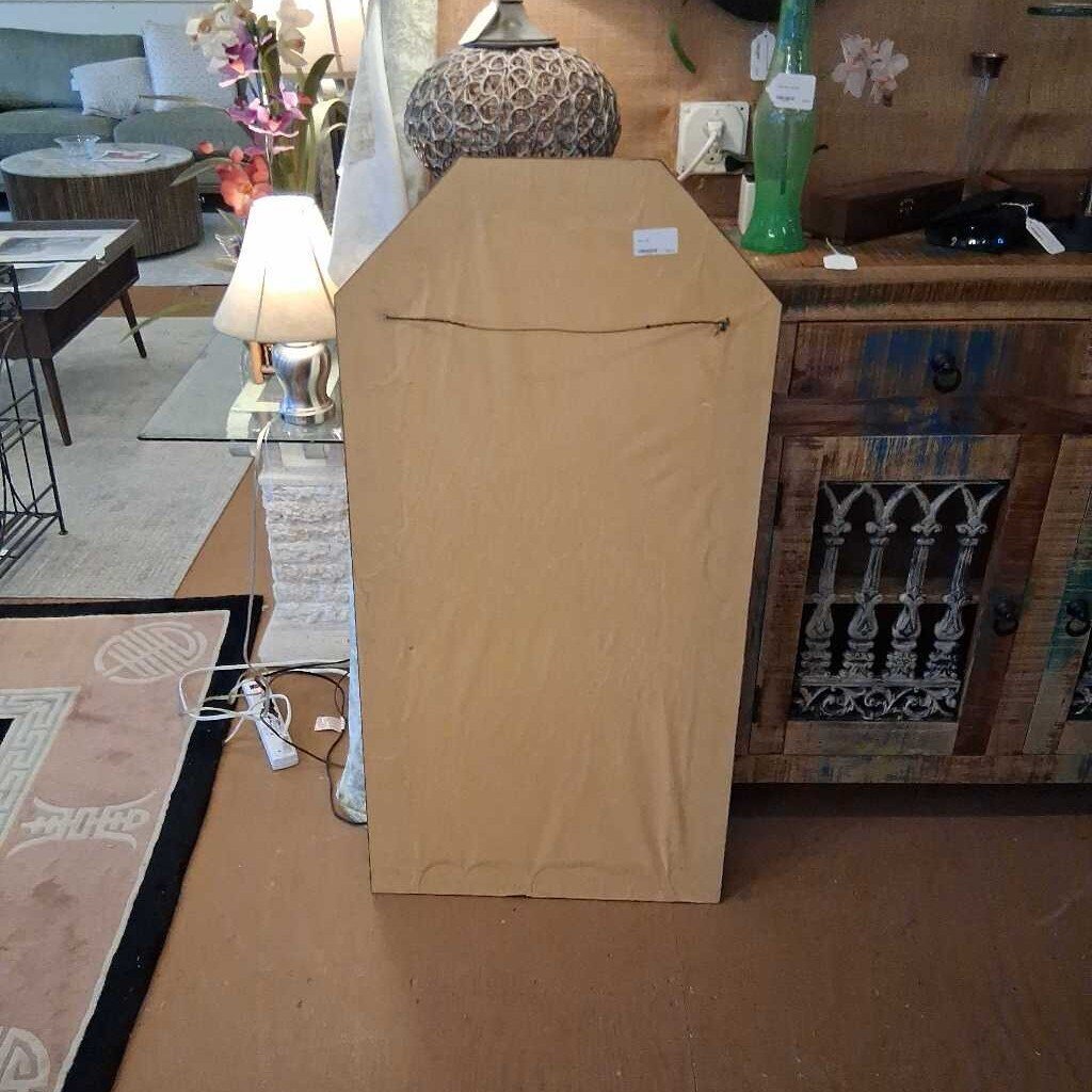 Cardboard box on a living room floor with furniture and decor in the background