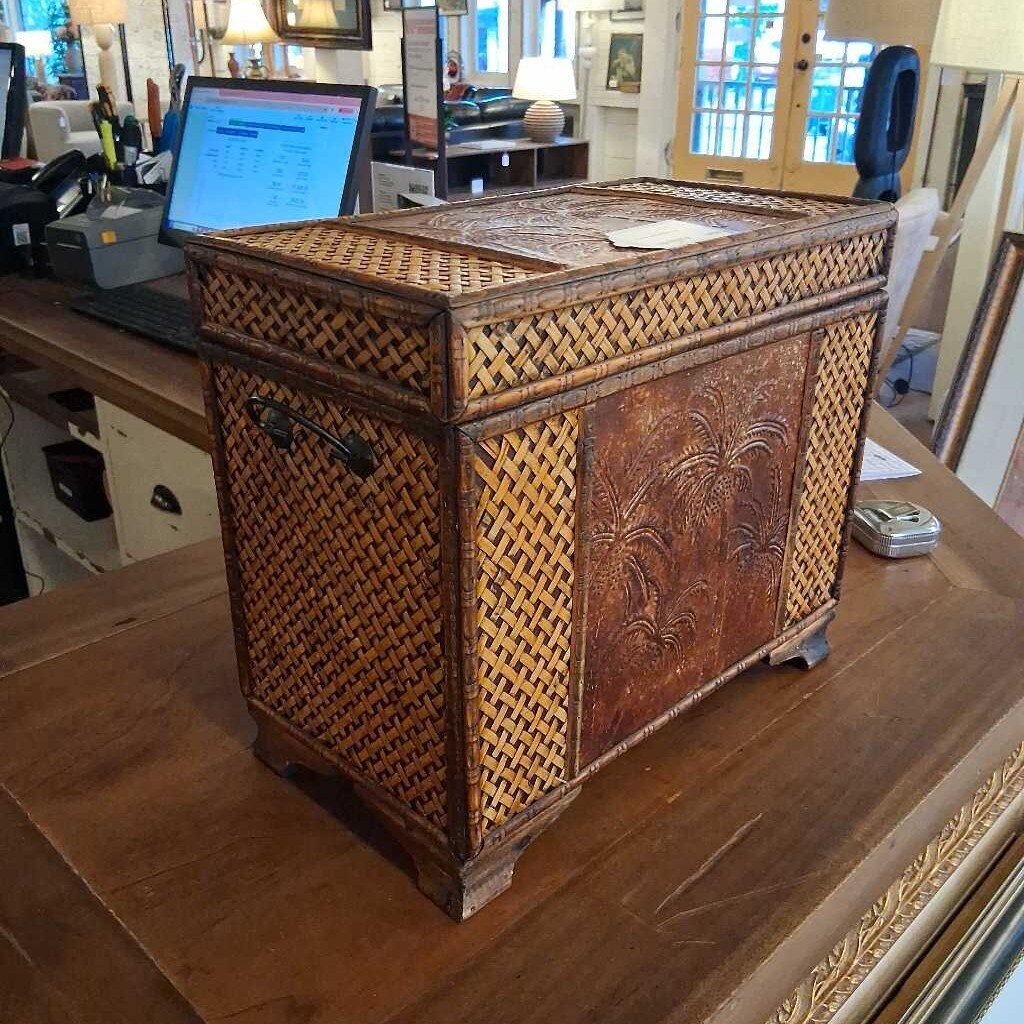 Wicker side table with decorative carvings on a wooden surface
