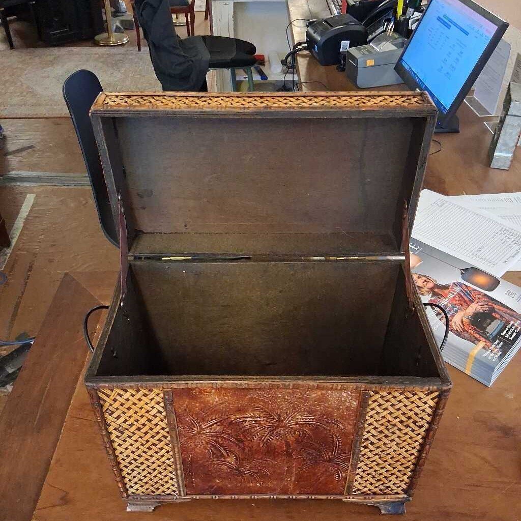 Vintage-style wooden chest with wicker sides on a wooden floor.