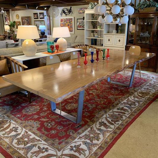 Wooden dining table with decorative items in a room with furniture and decor.