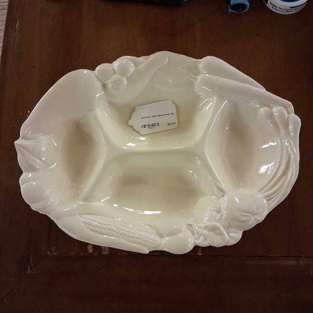 White ceramic dish with decorative elements on a wooden surface