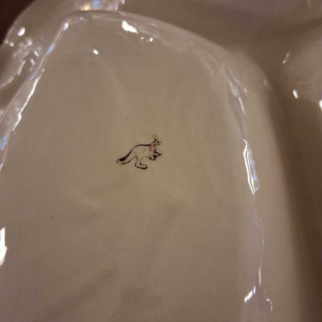 White ceramic plate with a small black design on a white background