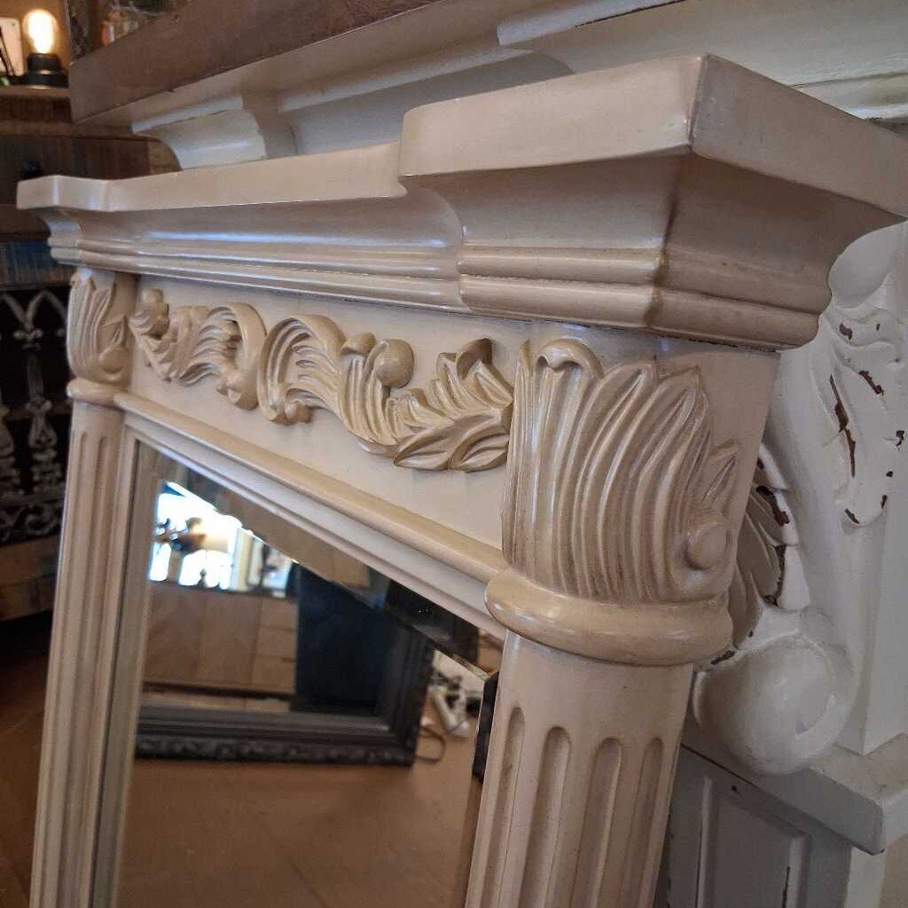 Decorative mirror with ornate frame on a brown floor