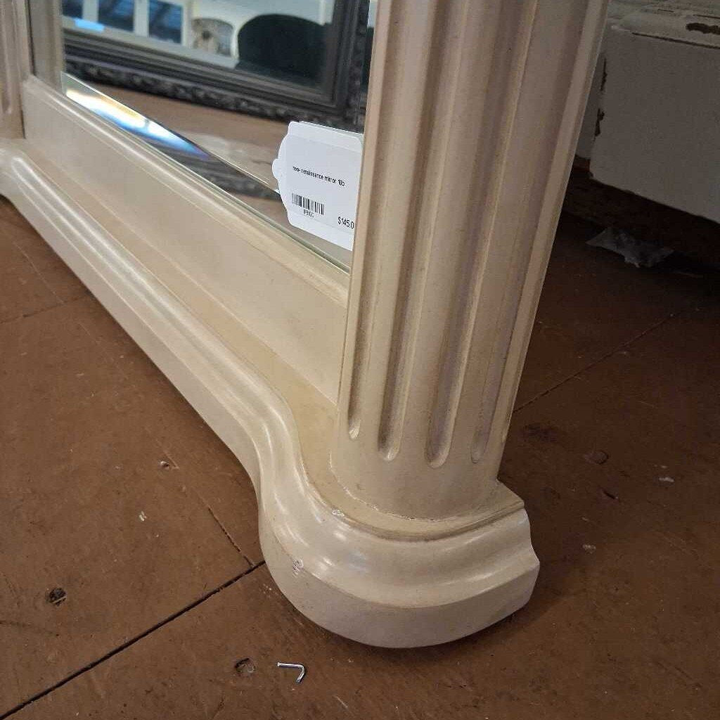 Decorative mirror with ornate frame on a brown floor