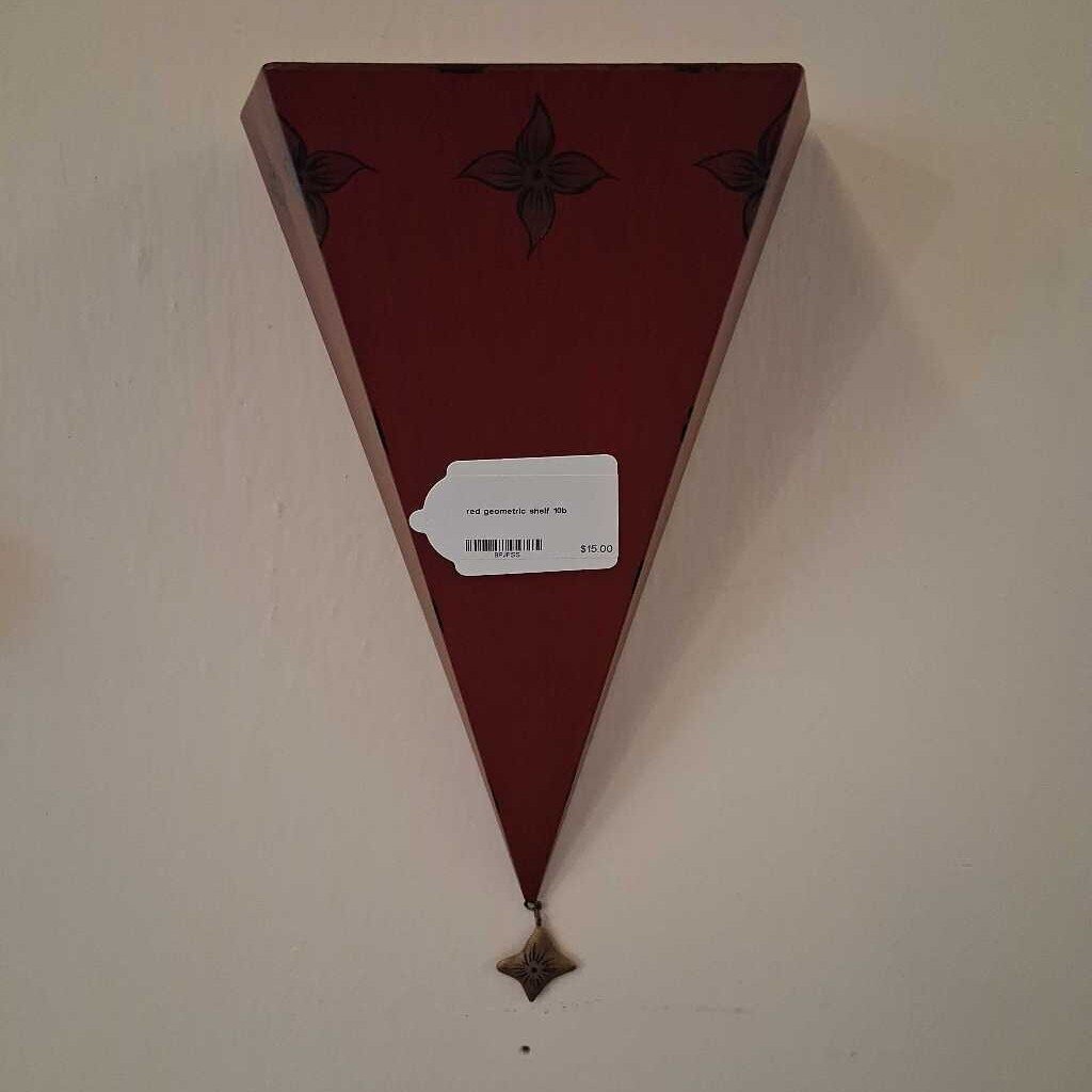 Triangular wooden shelf with decorative elements on a wall.