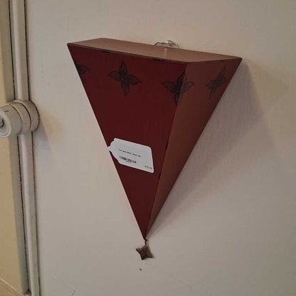 Triangular wooden shelf with decorative elements on a wall.