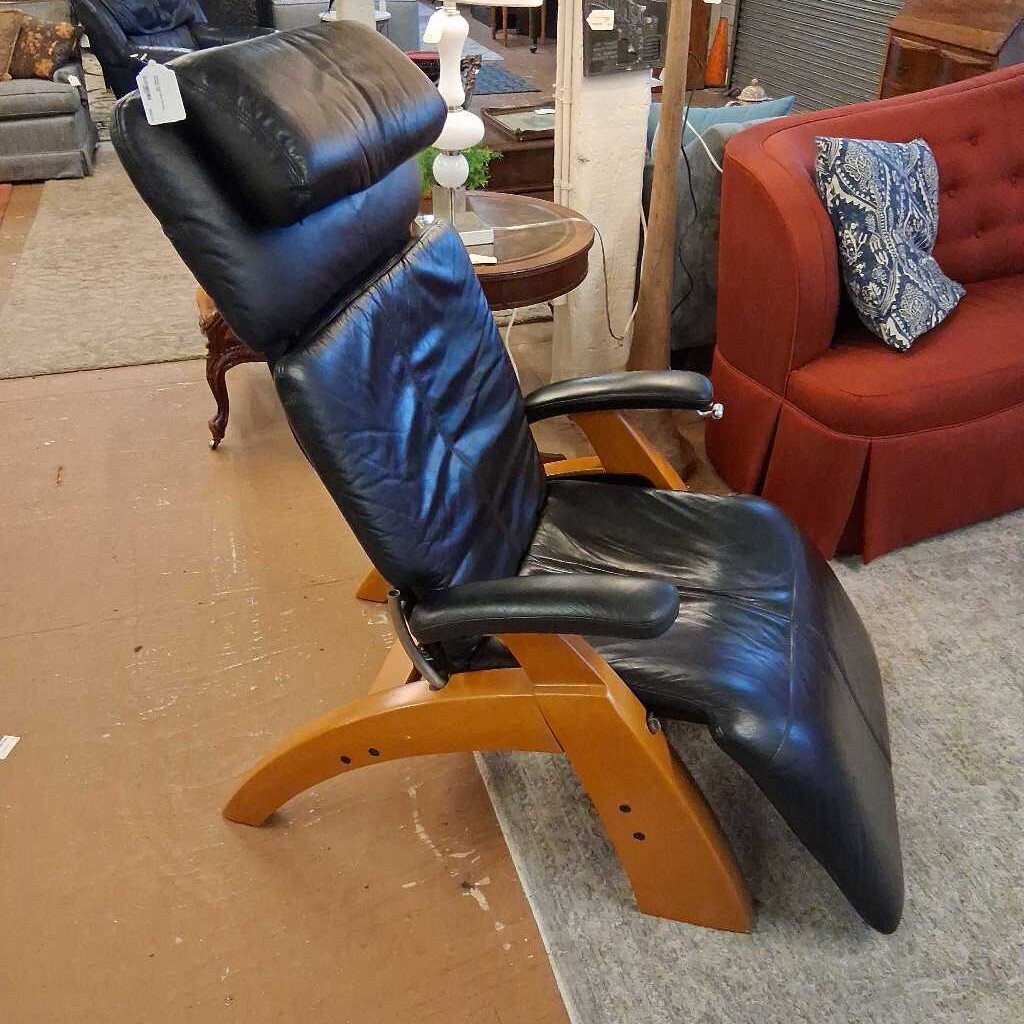 Black recliner chair with wooden base in a furniture store setting