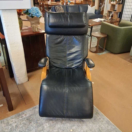 Black leather recliner chair in a furniture store setting
