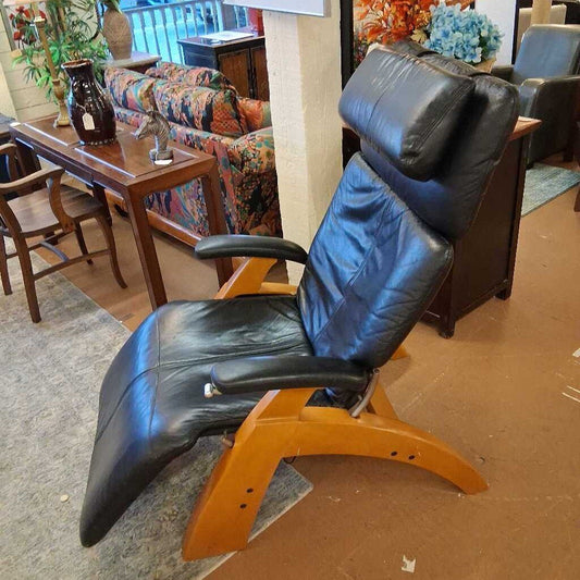 Black recliner chair with wooden frame in a furniture store setting