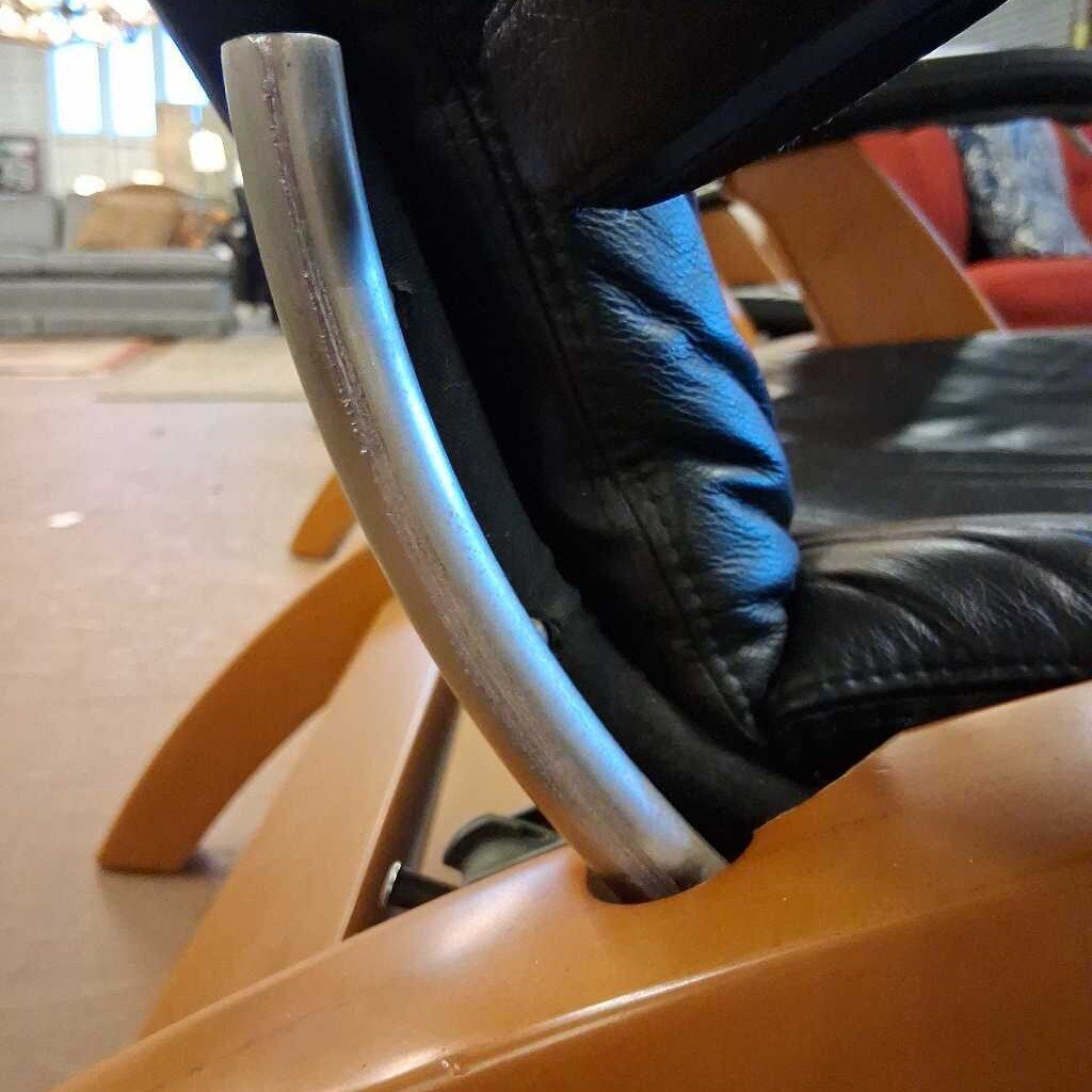 Close-up of a person sitting on a modern chair with a blurred indoor background