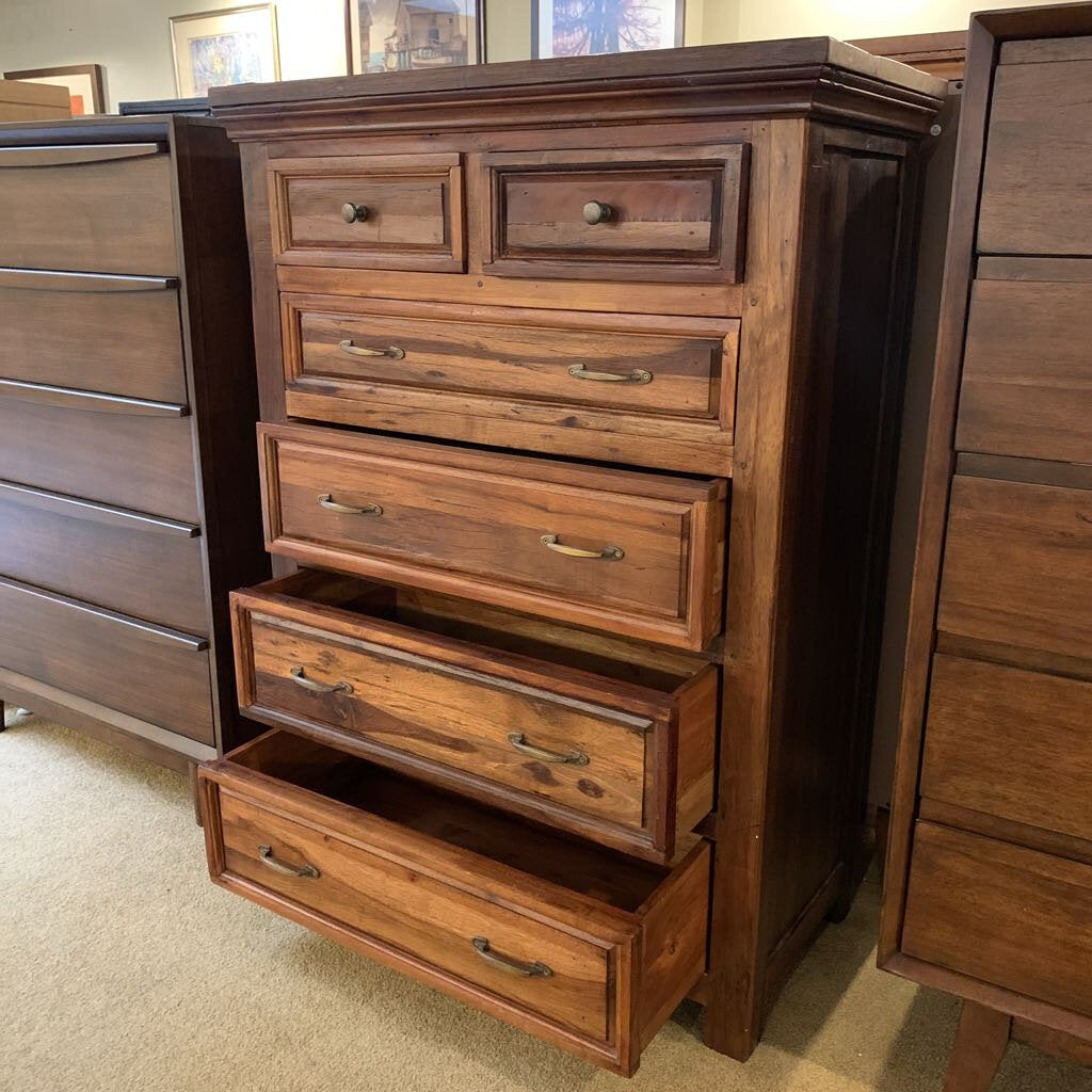 Wooden dresser with multiple drawers on a carpeted floor